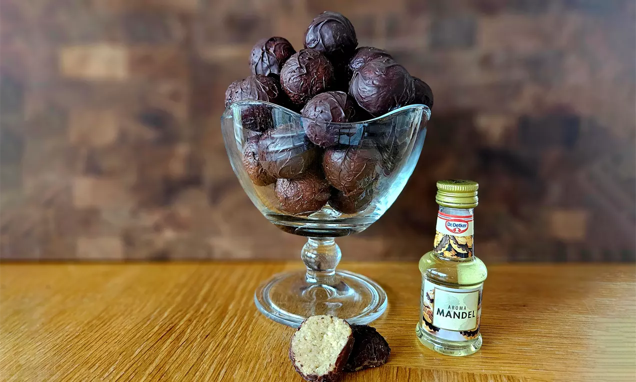 Mørkebrune Drageguf påskeæg med blød, let nubret chokoladeskal, fyldet synligt i et halveret æg, serveret i en klar glasbowle